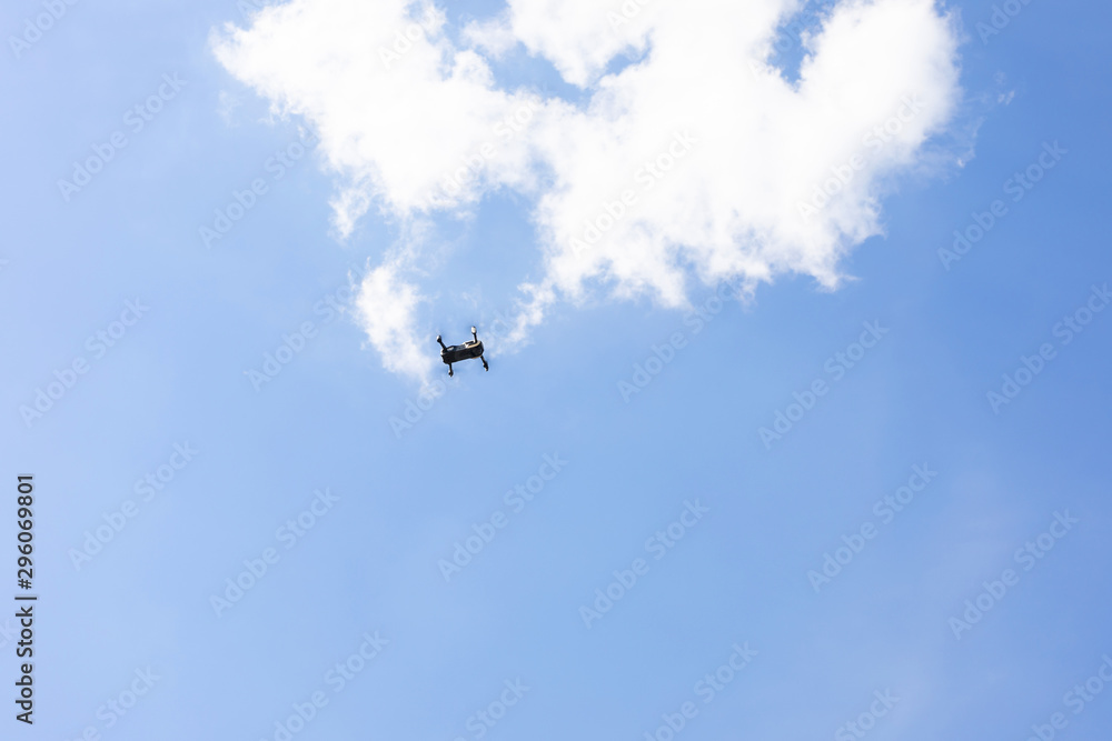 Drone flying in the sky with a mounted digital camera used for photographing and The quadcopter on sky background.