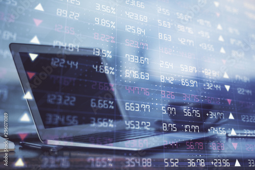 Stock market graph on background with desk and personal computer. Double exposure. Concept of financial analysis.