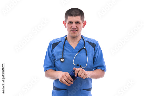 young doctor in blue uniform takes pills from jars isolated on white background