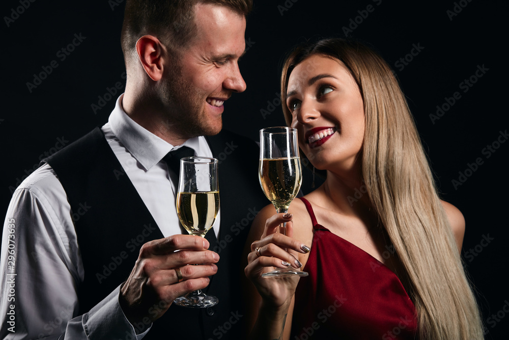 smiling positive couple enjoying free time at the restaurant. close up portrait, isolated black background, studio shot smiling positive couple enjoying free time at the restaurant. close up portrait, isolated black background, studio shot