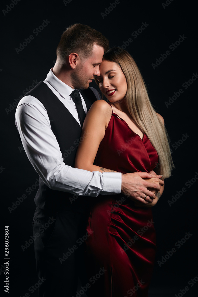 young pleasant man in shirt taking off his woman's dress, close up portrait, isolated black background, studio shot , copy space young pleasant man in shirt taking off his woman's dress, close up portrait, isolated black background, studio shot , copy space