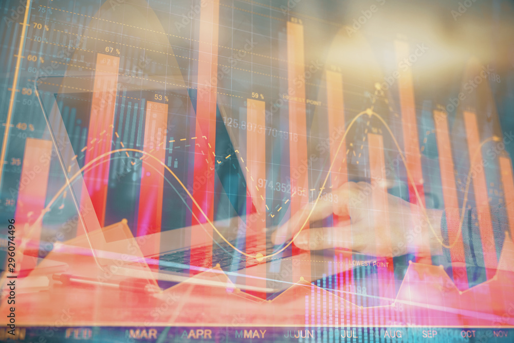 Double exposure of man's hands writing notes with laptop of stock market with forex graph background. Top View. Concept of research and trading.