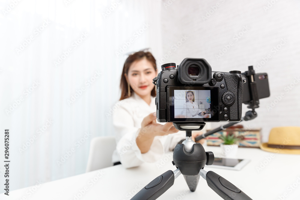 Young travel blogger girl reviewing in front of camera and recording video at home for vlog. Young travel blogger girl reviewing in front of camera and recording video at home for vlog.