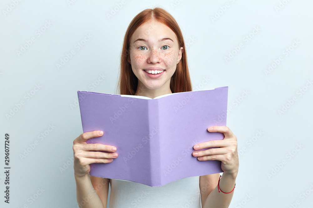 happy positive young woman gets knowledge, pretty girl is learning a subject. close up portrait, isolated white background, studio shot happy positive young woman gets knowledge, pretty girl is learning a subject. close up portrait, isolated white background, studio shot