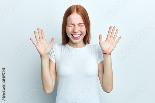 Wallpaper Mural Happy crazy funny carefree young woman keeps hands raised, being in high spirit, isolated over white background. Optimistic cheerful woman expresses positiveness. Torontodigital.ca