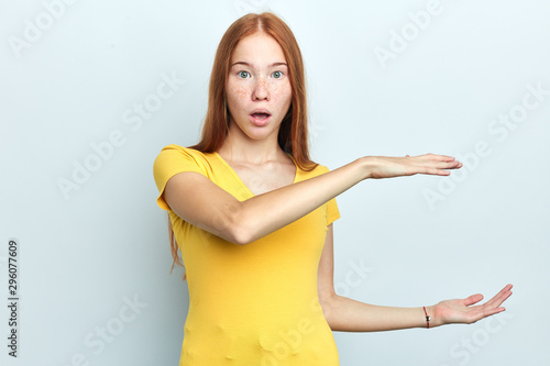 Wallpaper Mural Shocked young surprised woman with wide open mouth shows something big in size with hands, demonstrates height of statue, isolated over white background, sale Torontodigital.ca