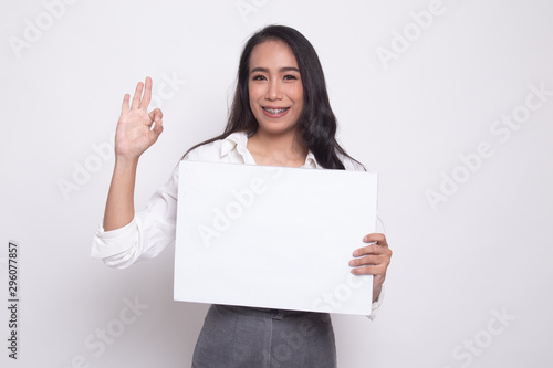 Young Asian woman show OK with white blank sign.