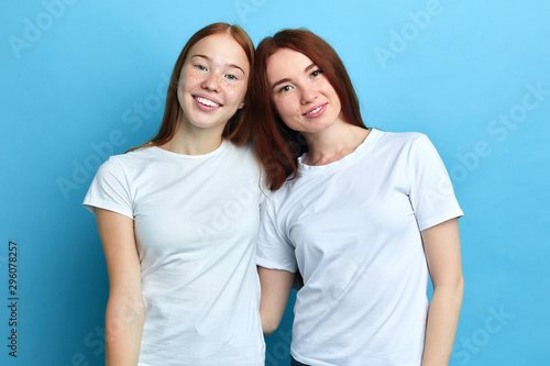 smiling beautiful pleasant women embracing each other, close up portrait, studio shot.free time, spare time .