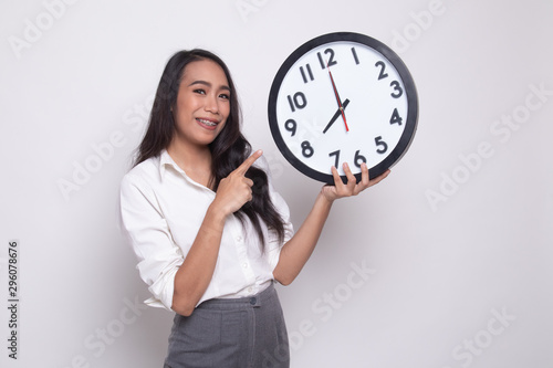 Young Asian woman point to a clock.