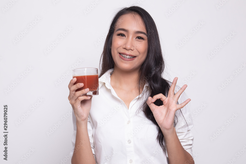 Young Asian woman show OK with tomato juice. Young Asian woman show OK with tomato juice.