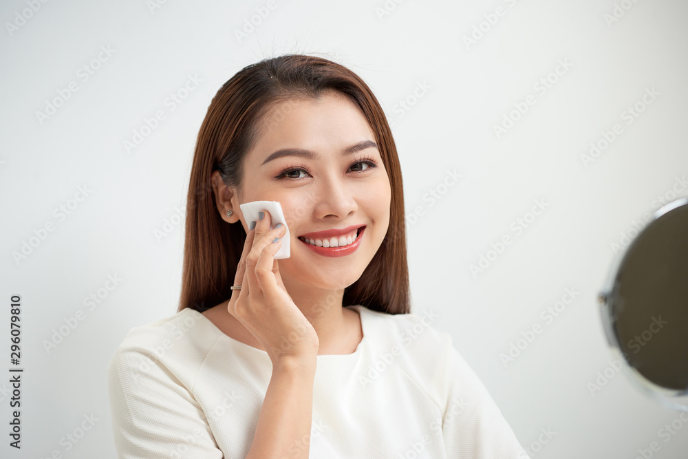 beautiful girl cleans the face of makeup with a cotton pad beautiful girl cleans the face of makeup with a cotton pad