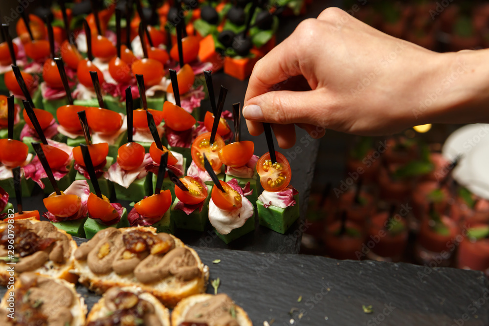 Hand takes the vegetable canapés