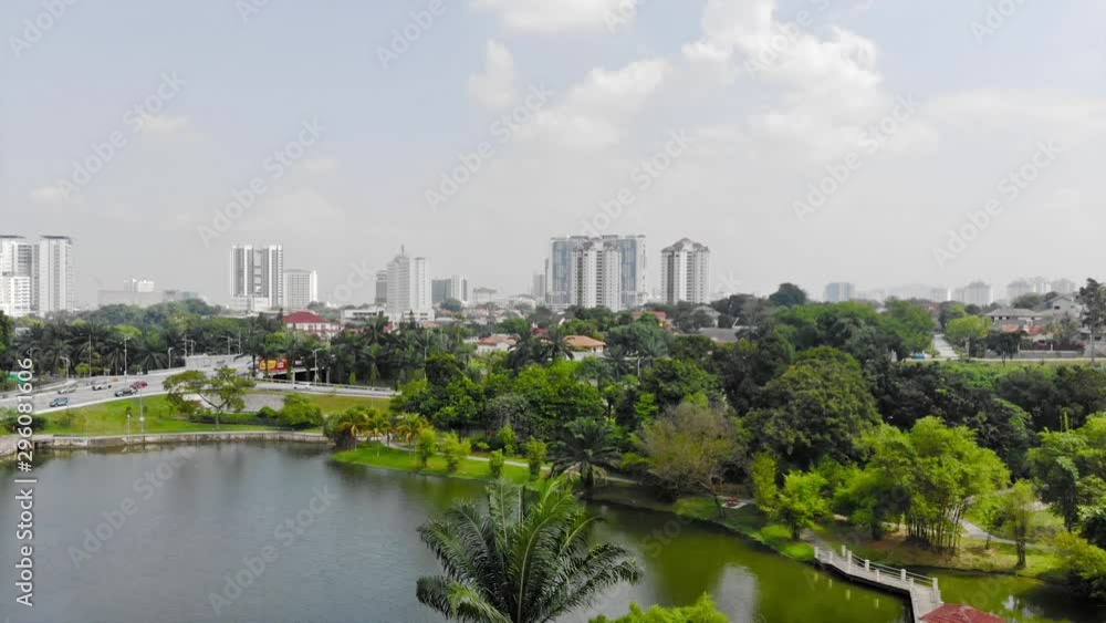 Top Aerial View of Buildings in Malaysia City and Full Road Vehicles Near Lakes and Trees Full of Trees - Moving Down Top Aerial View of Buildings in Malaysia City and Full Road Vehicles Near Lakes and Trees Full of Trees - Moving Down