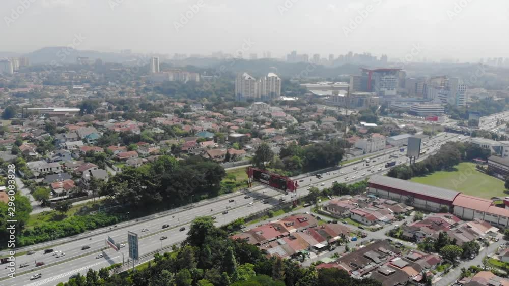 Top Aerial View Of Highways Full Of Vehicles Between Housing And City In Malaysia With A View Of Mount Indah - Backwards Top Aerial View Of Highways Full Of Vehicles Between Housing And City In Malaysia With A View Of Mount Indah - Backwards