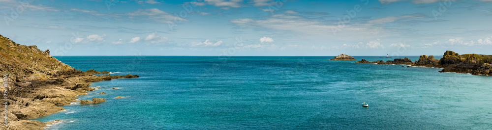 panorama view of rocky coast and ocean landscape with a lone fisherman in a small boat