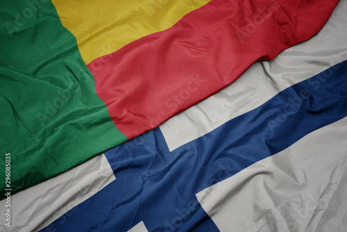 waving colorful flag of finland and national flag of benin.