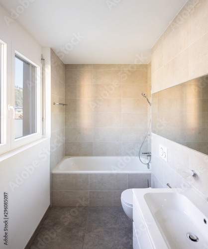 Modern minimal bathroom with large tile bathtub