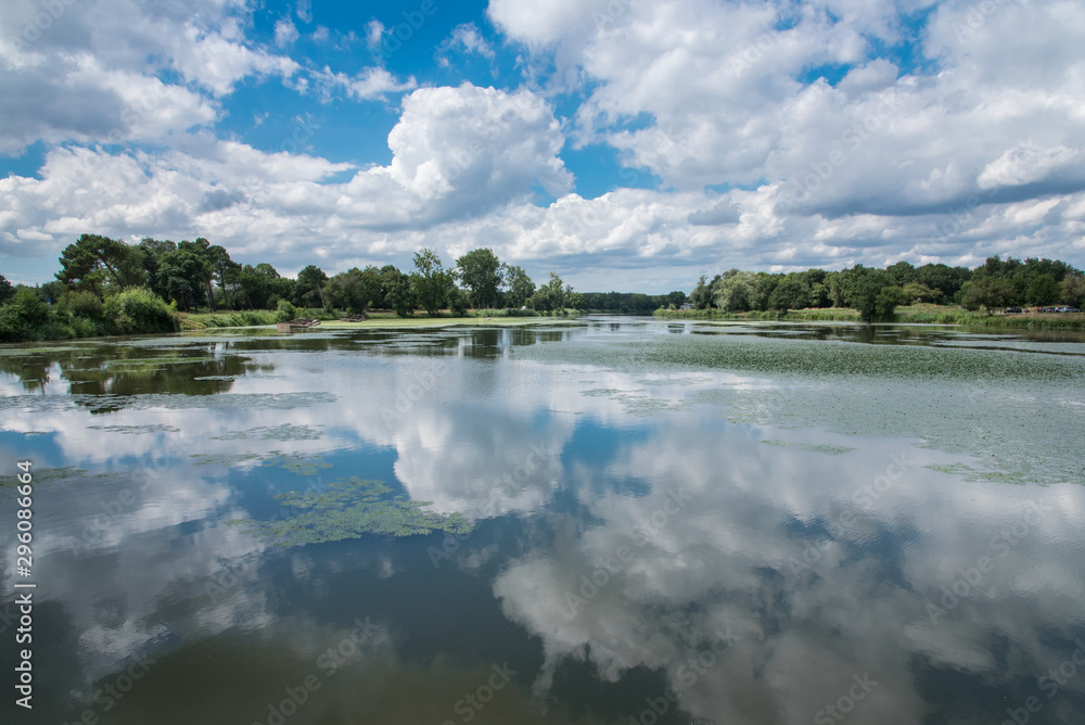 reflets de nuages sur un lac avec le ciel bleu et des nuages en été