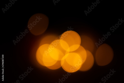 Out of focus yellow and warm lights on black background. © Trygve