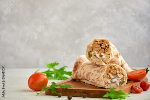 Shawarma with chicken on wooden board, closeup with space for text  