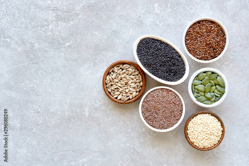 Various healthy seeds in bowls  flaxseed  sesame  pumpkin seeds  sunflower  psyllium  nigella. Top view  flat lay with space for text