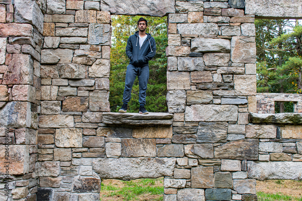 young man outdoors standing in window of abandoned building young man outdoors standing in window of abandoned building