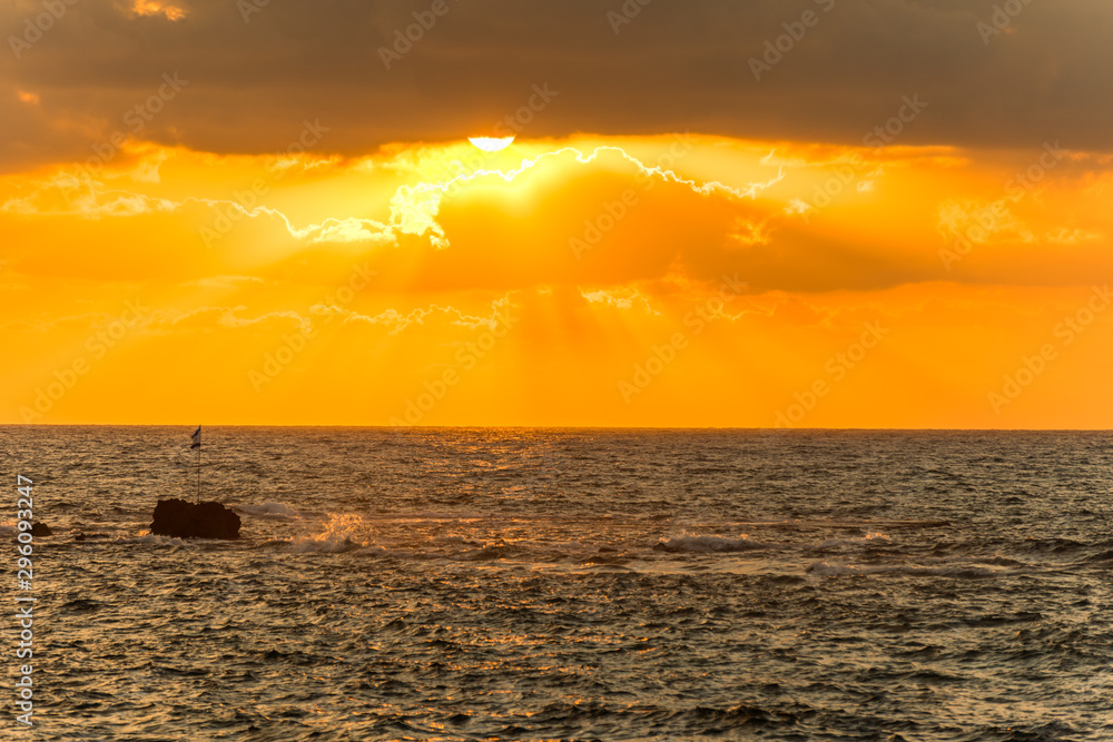 Beautiful sunset and golden twilight, and clouds and a longly cruise ship sailing on the Mediterranean Sea in Tel Aviv, Israel