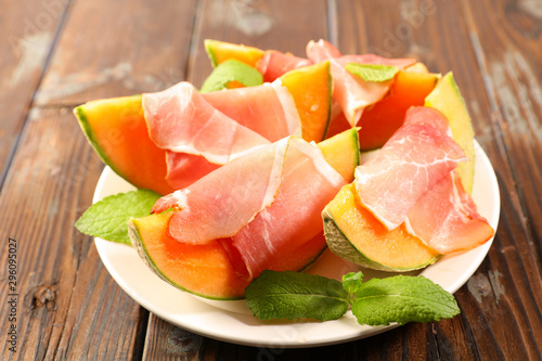 plate of melon slice with prosciutto ham and basil