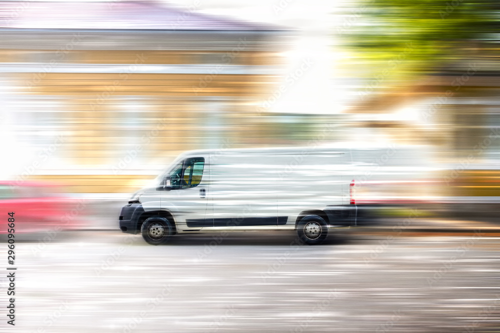 White van speeding down a city street. White van speeding down a city street.