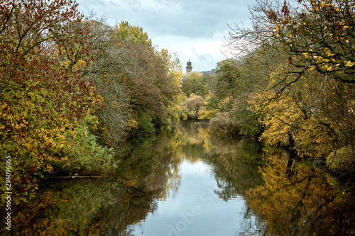The River Aire wends its way through autumn trees towards the historic model village of Saltaire in Yorkshire