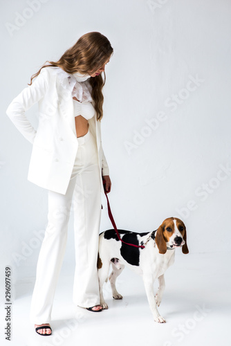 portrait of young woman in white suit with dog