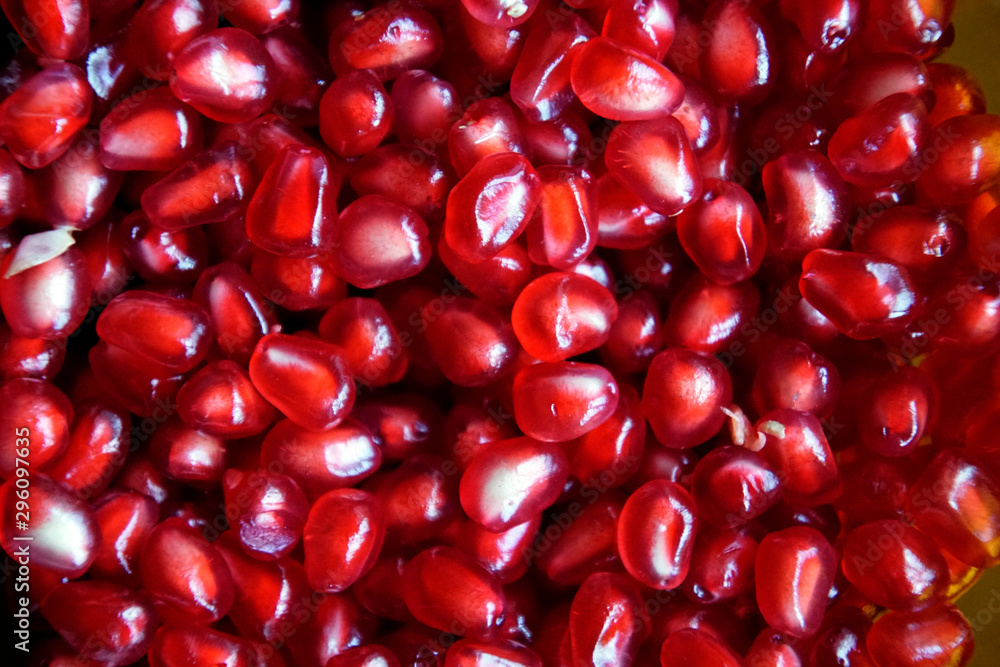 Refined garnet grains of ruby color. Juicy beautiful fruit. Background texture. Close-up. Refined garnet grains of ruby color. Juicy beautiful fruit. Background texture. Close-up.