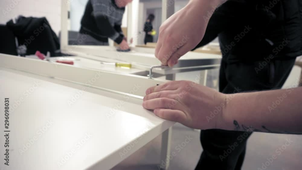 Man tightening screw with hex wrench Man tightening screw with hex wrench