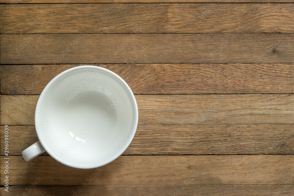 Empty white cup for tea or coffee on wooden table. Copy space. Flat lay. Top view. Unfilled mug Empty white cup for tea or coffee on wooden table. Copy space. Flat lay. Top view. Unfilled mug