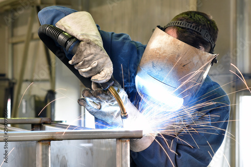 welder works in metal construction - construction and processing of steel components photo