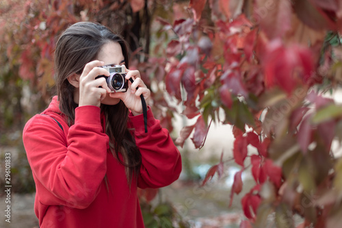 Young photographer using a vintage camera in autumn