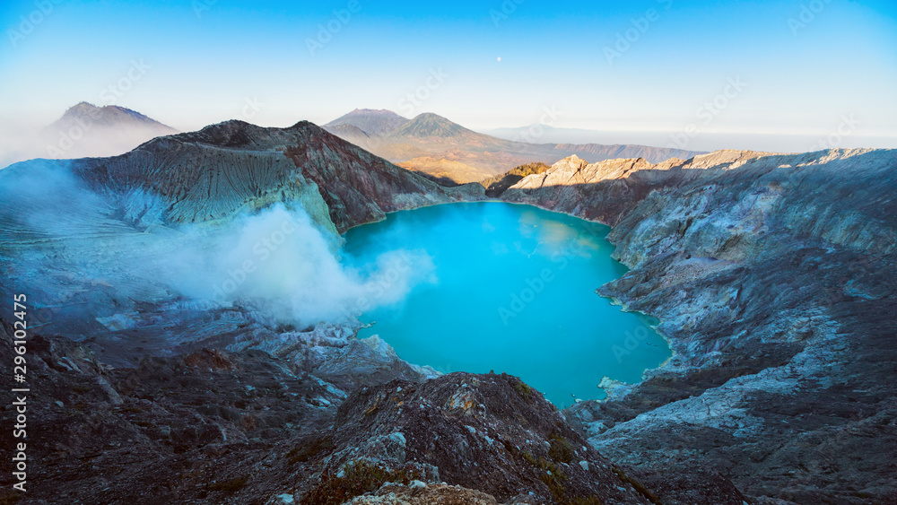 Sunrise panoramic view of Kawah Ijen volcano crater, largest in world sulphur acidic lake with hot steam, poisonous fume. Popular travel destination, adventure hike tour in East Java, Indonesia