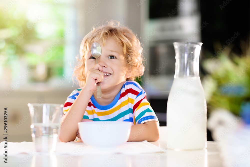Child eating breakfast. Kid with milk and cereal. Child eating breakfast. Kid with milk and cereal.