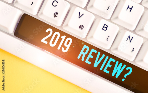 Handwriting text 2019 Review Question. Conceptual photo remembering past year events main actions or good shows White pc keyboard with empty note paper above white background key copy space photo