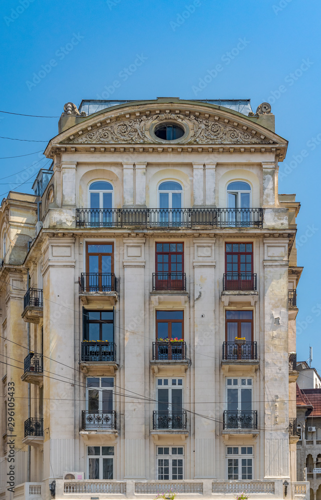 An old building facade in Bucharest, Romania. An old historic building a sunny summer day with blue sky in Bucharest, Romania
