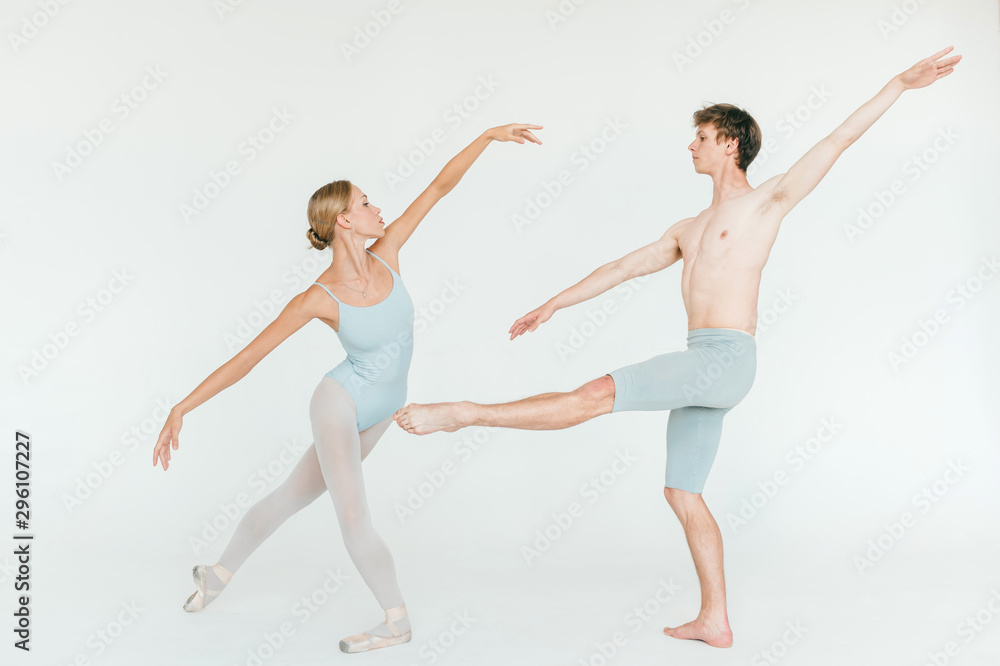 Two athletic modern ballet dancers are posing against white studio background Two athletic modern ballet dancers are posing against white studio background