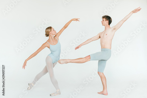 Two athletic modern ballet dancers are posing against white studio background