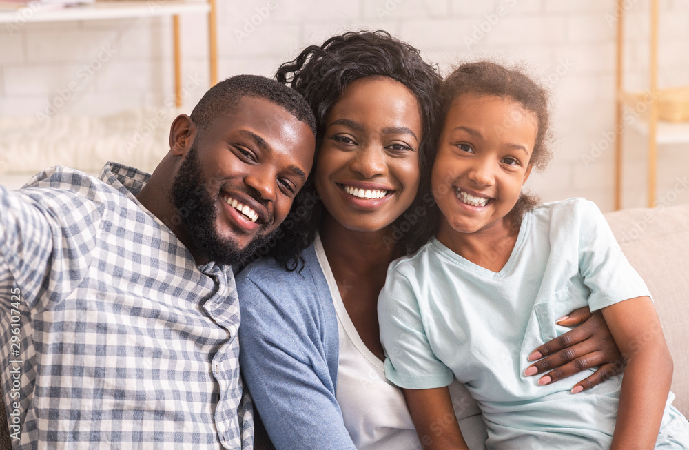 Smiling black man taking selfie with his wife and daughter Stock Photo ...