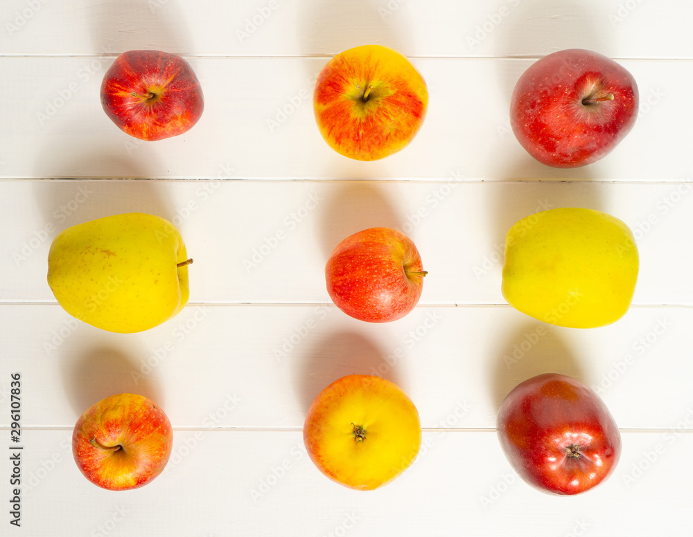 Red and yellow apples on a white background. Autumn composition. Pattern.