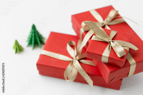 winter holidays  new year and celebration concept - red gift boxes and origami christmas trees on white background