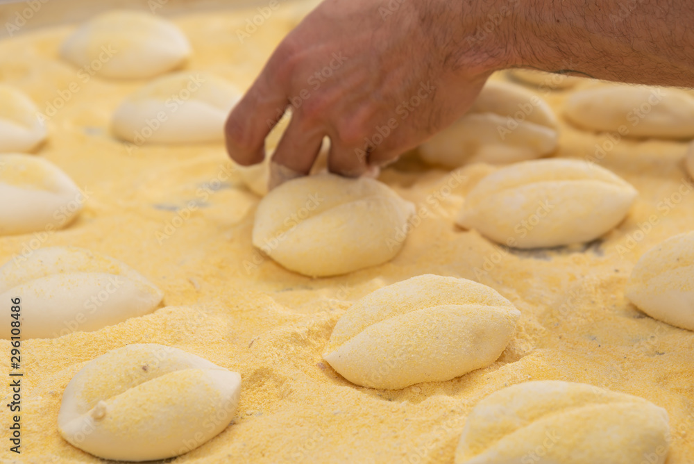 Fresh raw dough in product line. Cooks roll the dough for baking, pieces of raw dough on a metal board