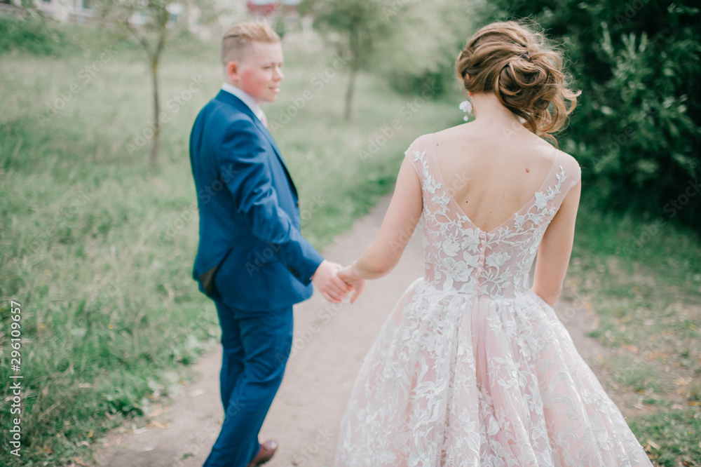Beautiful wedding couple walking along road at nature Beautiful wedding couple walking along road at nature