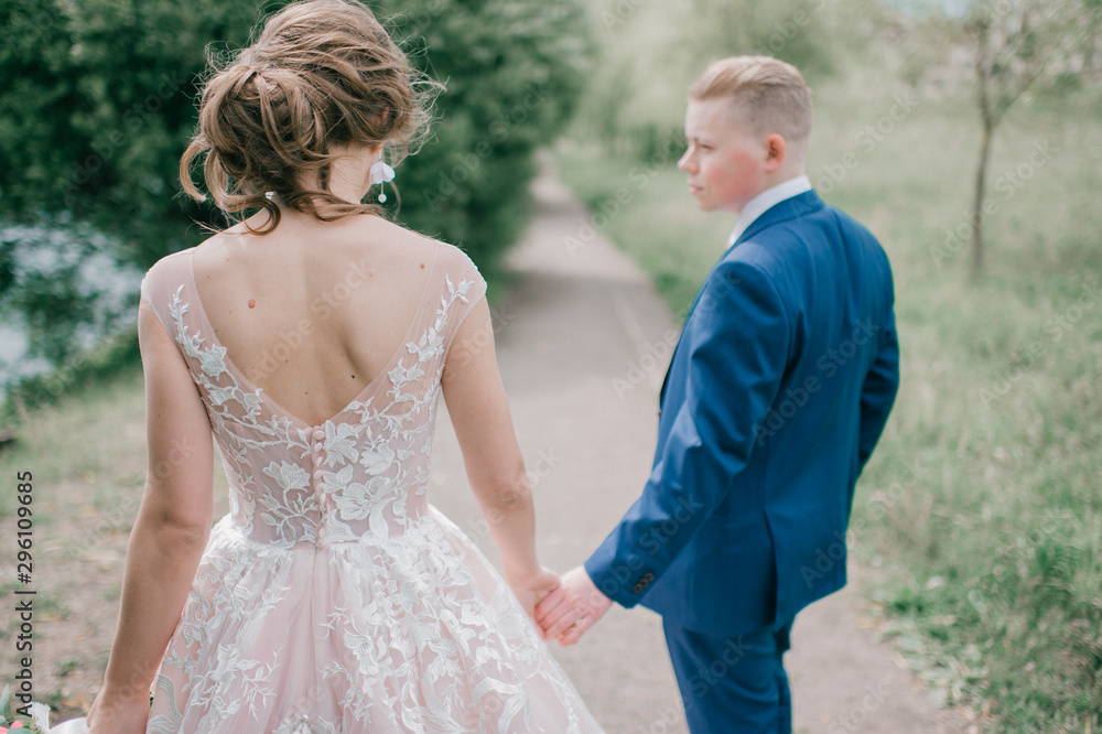 Beautiful wedding couple walking along road at nature Beautiful wedding couple walking along road at nature