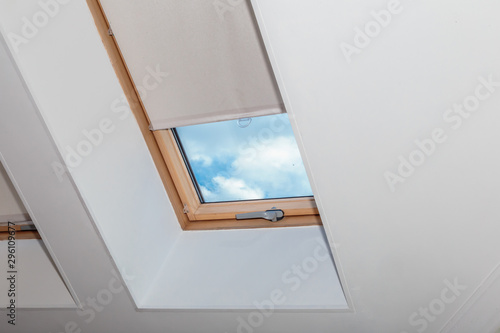 Attic window. Curtain on the roof window. Jalousie.