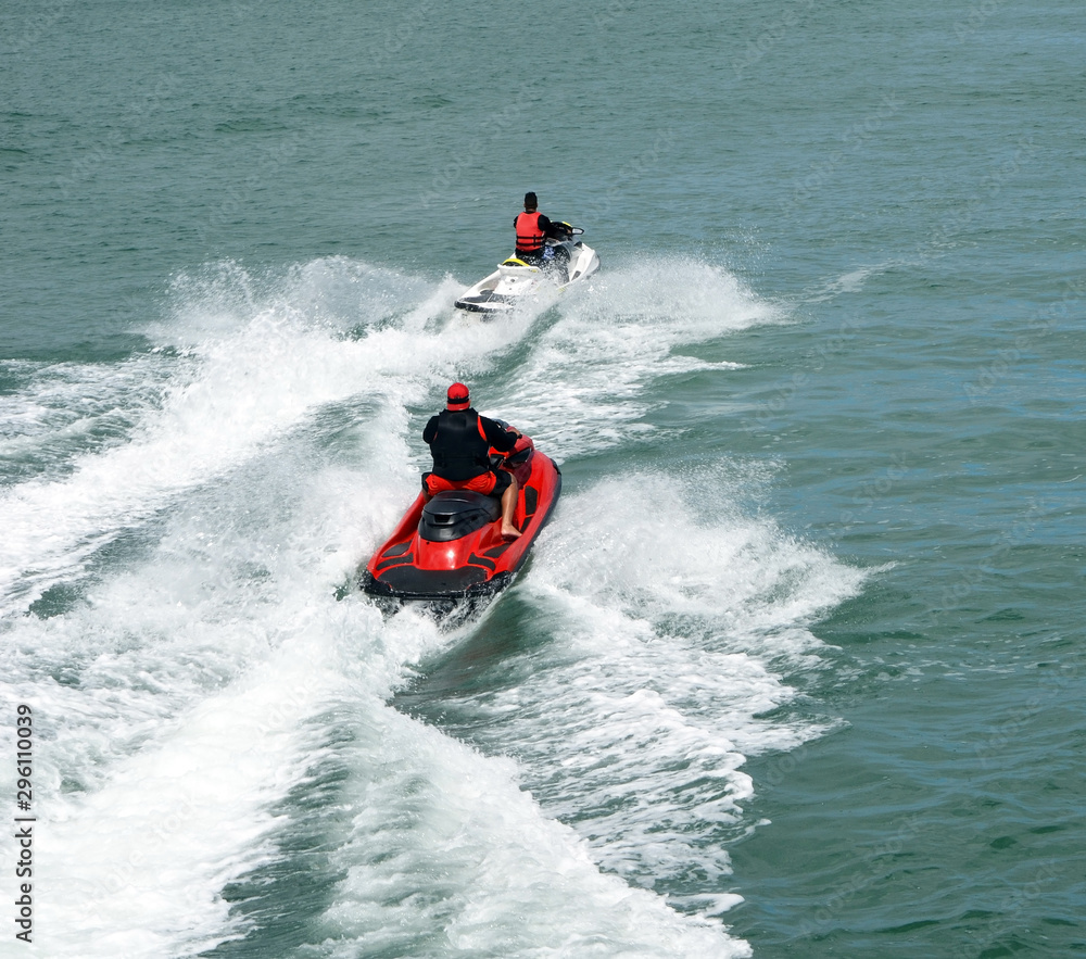 Two speeding jet skiers leaving wake trails Two speeding jet skiers leaving wake trails